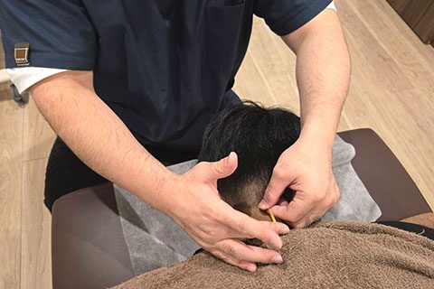 原因を確かめながら施術する院長の手元