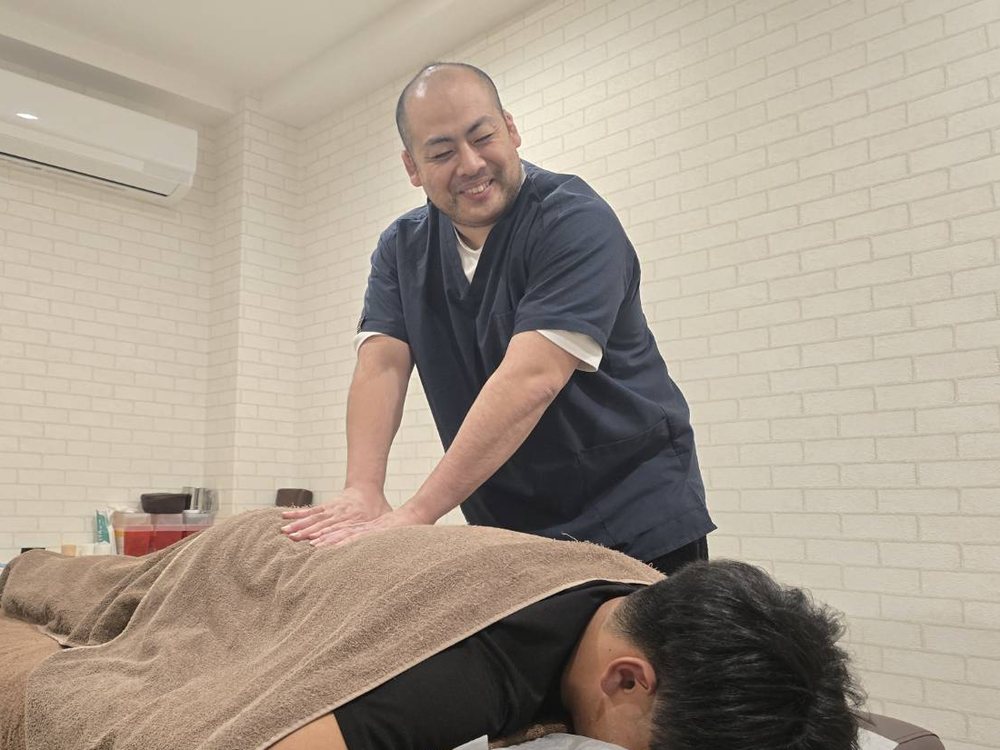 手技で施術をする院長